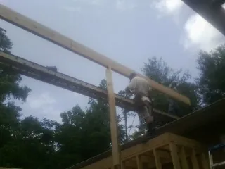 Carpenter setting a ridge beam over a new addition frame — Ice Dam Removal by Roofing Brothers in Bordentown