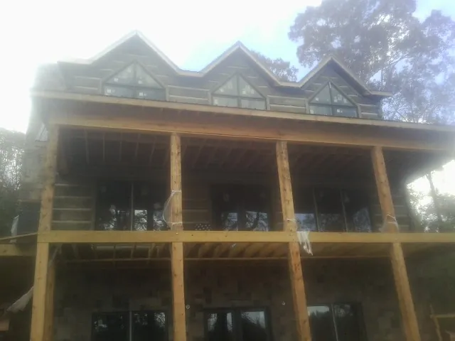 Dormers and porch framing on a large log home under construction — Roof Coating work by our crew in Bordentown